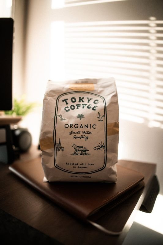 The front of the Tokyo Coffee bag on a desk in soft backlight