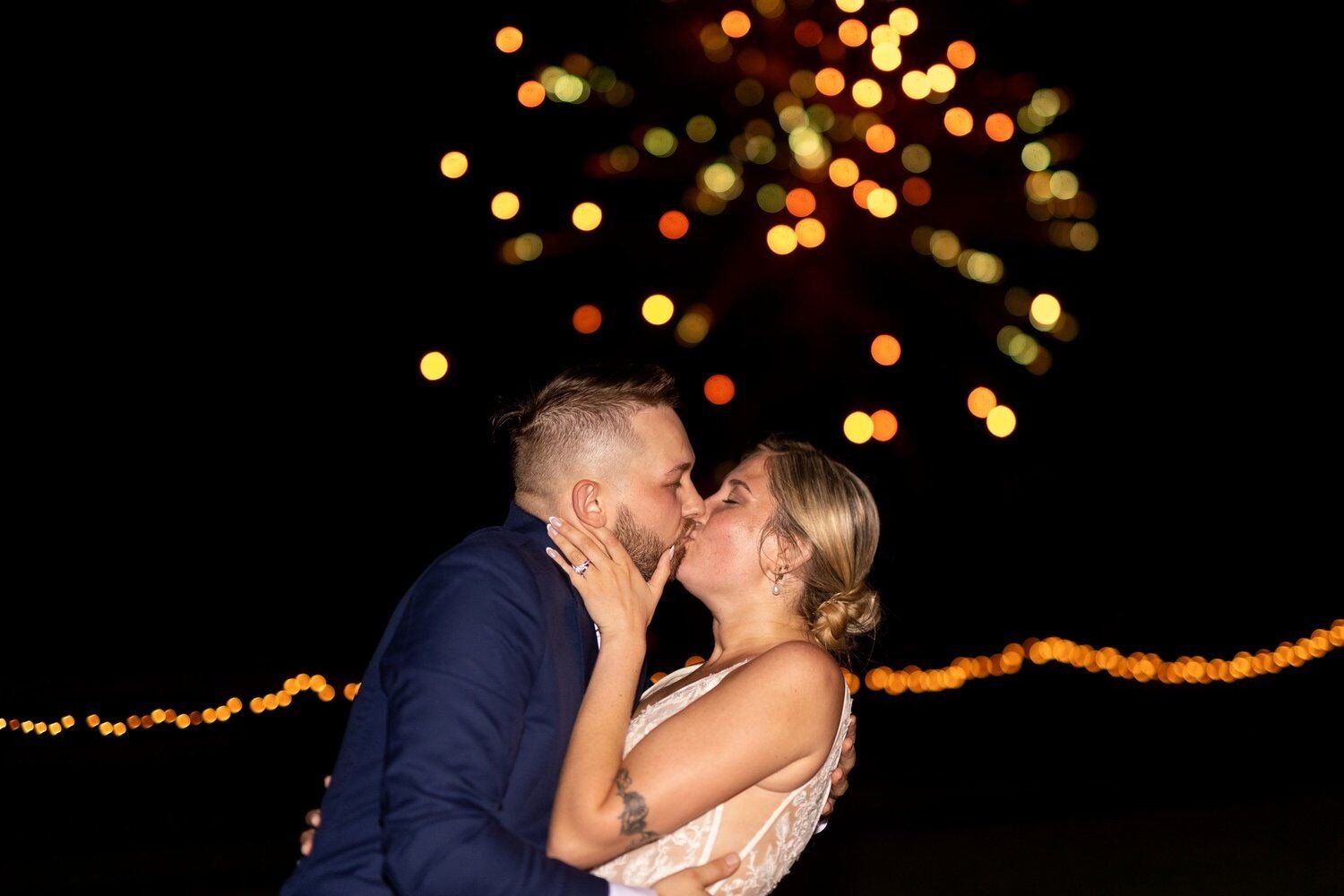 A couple kissing under sparklers at the end of the night